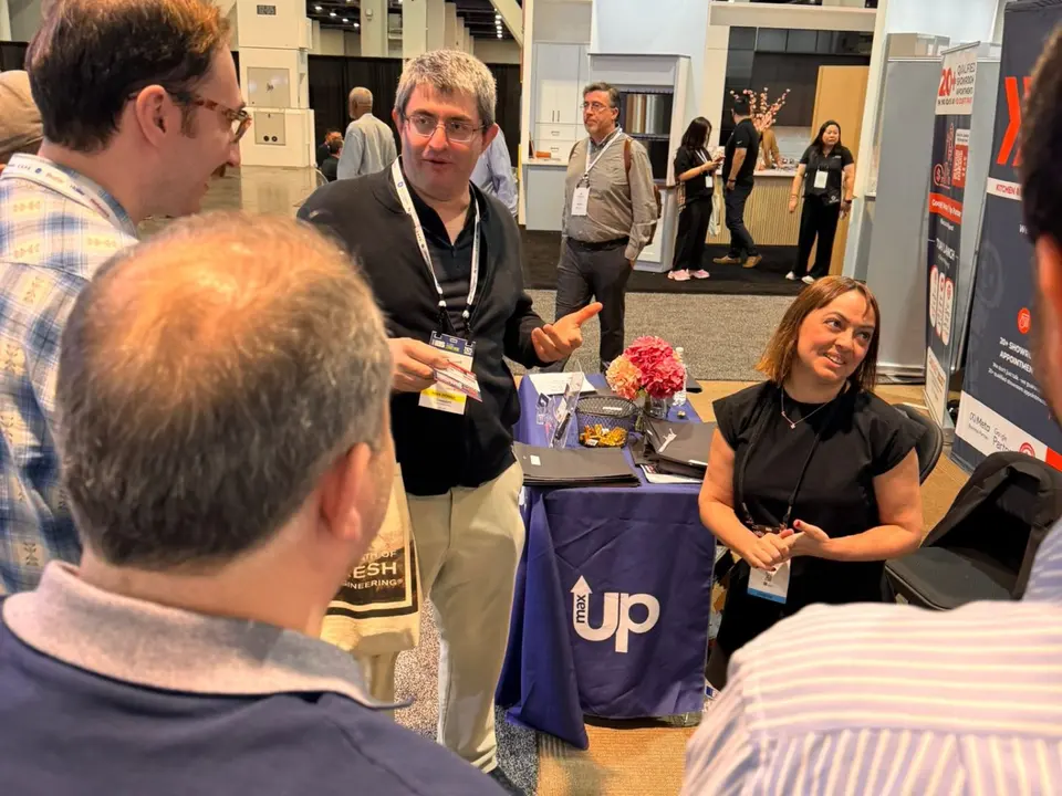 Attendees in conversation at the CabinetBoost table on the KBIS 2025 show floor