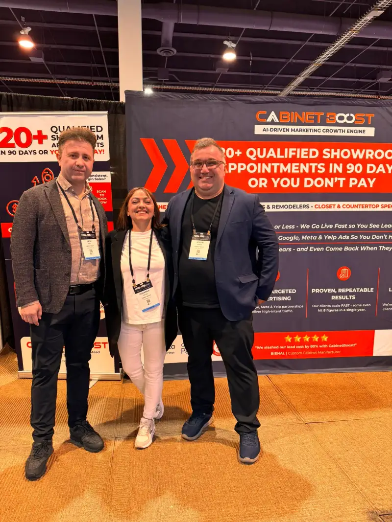 Three people at the CabinetBoost booth backdrop, KBIS 2025 Las Vegas, Booth SL3205 — day one